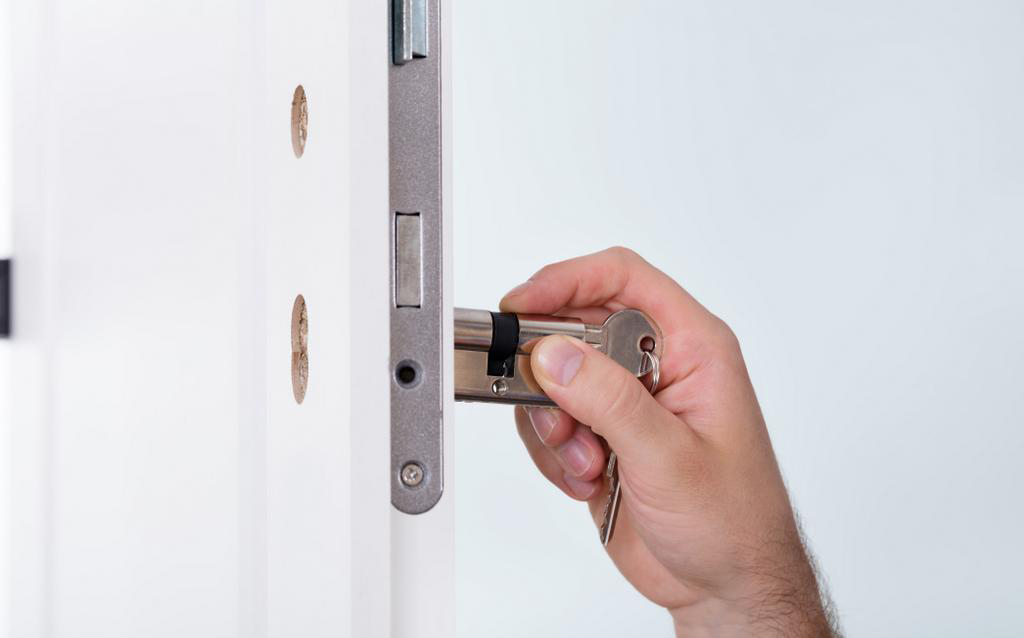 Man's Hand Installing Door Lock In Door